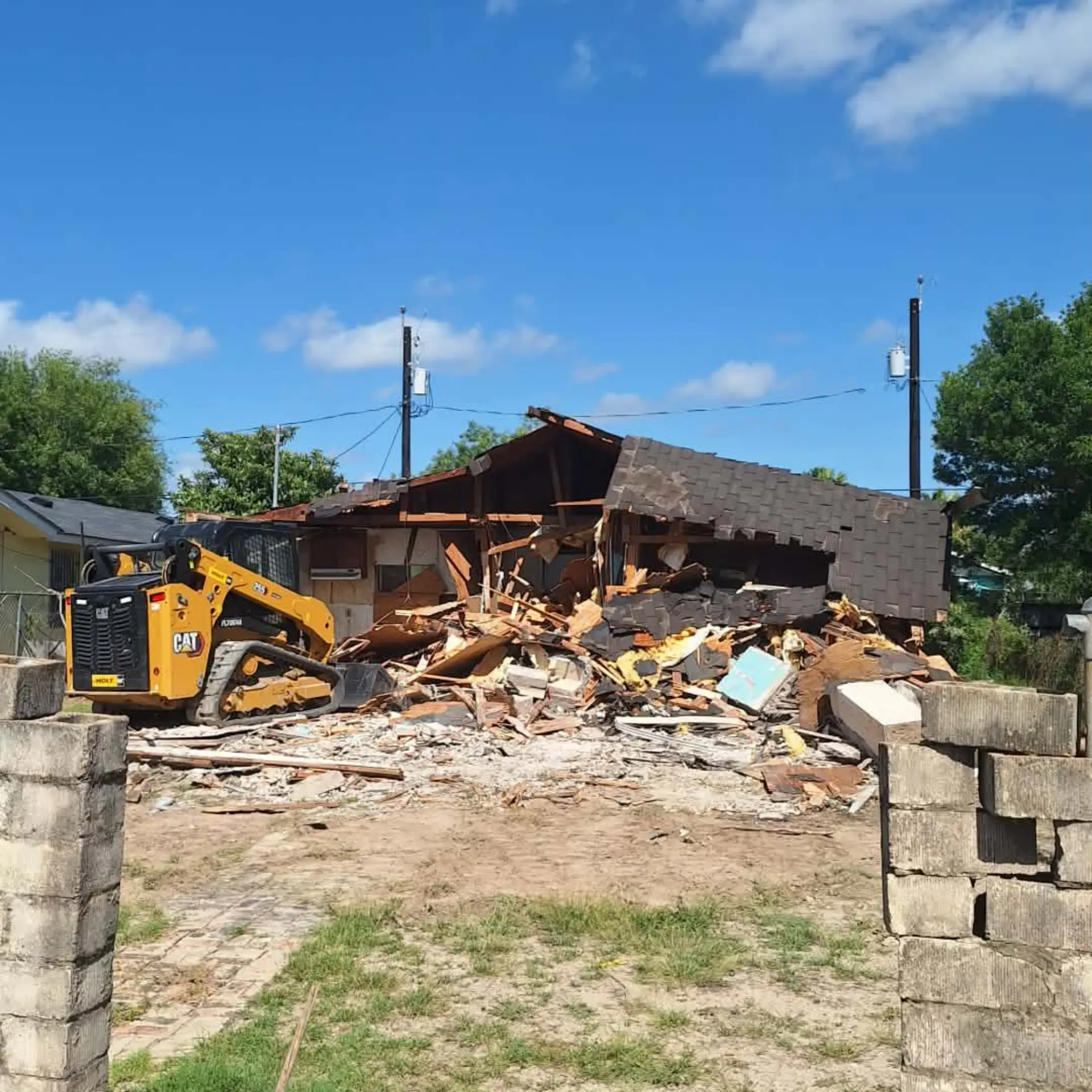 Skid steer tearing down a single-story house